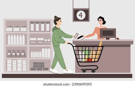 A woman with food in a cart makes a contactless payment by phone at the cash register in a supermarket. The concept of contactless payments