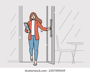 Woman freelancer with laptop leaves cafe with transparent window and rejoices at opportunity to work where it is convenient. Successful businesswoman opens door of meeting room in modern office