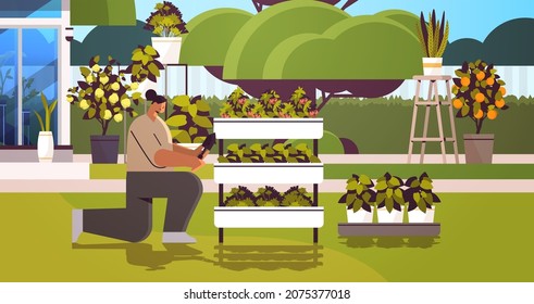 woman gardener with shovel taking care of potted plants at backyard greenhouse or home garden horizontal