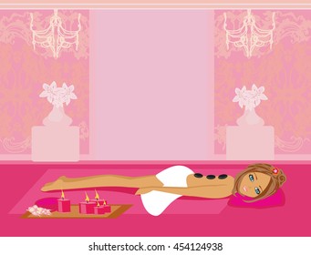 woman getting hot stone massage in spa salon