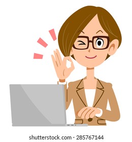 Woman glasses shows a hand sign of acknowledgment in front of a laptop