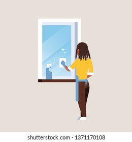 woman in gloves and apron cleaning window with rag cleaner spray rear view african american housewife doing housework concept flat full length