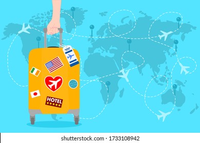 Woman hand is holding a Orange Travel bag with sticker on the blue world map and has airplane. Vacation time around the world. Enjoy international trip . Tourism, Journey concept. 