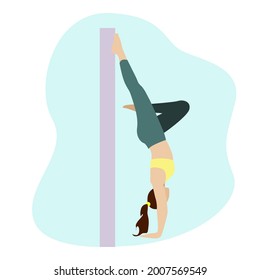 A woman in a handstand against the wall. Sports and yoga to maintain physical fitness.