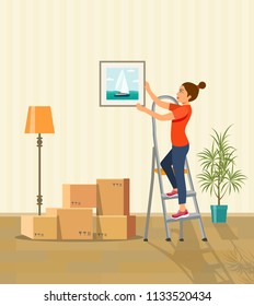 Woman hanging picture on the wall. Moving boxes in new house. Vector flat style illustration