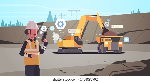 woman in helmet using walkie talkie controlling excavator loading soil on dump truck professional equipment working on coal mine production opencast stone quarry background portrait horizontal