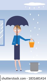 Woman holding bucket and umbrella in house to protect against leaking plumbing pipe