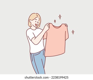 woman holding clean t shirt. Hand drawn style vector design illustrations.