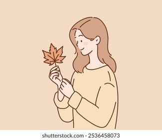  young woman holding fallen leaf.
Hand drawn style vector design illustrations.