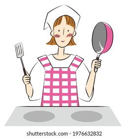 Woman holding a frying pan and a turner in front of the stove