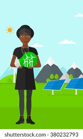 Woman holding lightbulb with windmills inside.
