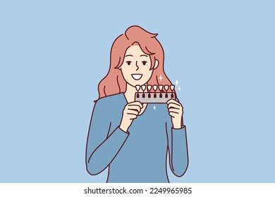 Woman holds device to determine shade of teeth passes test for quality of toothpaste. Long-haired girl demonstrates snow-white smile after whitening procedure at dentist. Flat vector illustration 