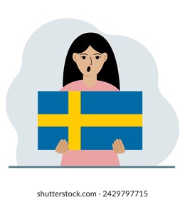 A woman holds the flag of Sweden in his hands. The concept of demonstration, national holiday or patriotism. Nationality.