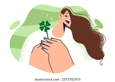 Woman holds four-leaf clover petal and rejoices at approaching holiday of St. Patrick day. Girl who found clover plant, which is symbol of celebration of parties on Patrick day on march 17