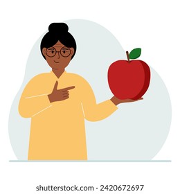 A woman holds a fresh and red apple in his hand. Woman eats an apple. Healthy food concept.