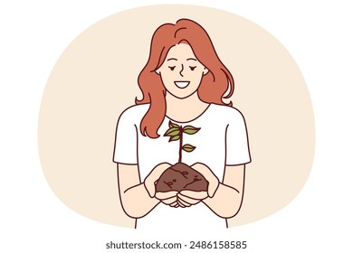 Woman holds handful of earth with plant drawing attention to problem of ecology and pollution or CO2 emissions. Happy girl doing plant cultivation and care for environment or ecology as volunteer