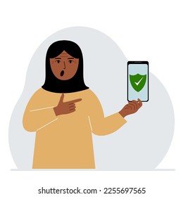 A woman holds in his hand a mobile phone on which antivirus software is installed.