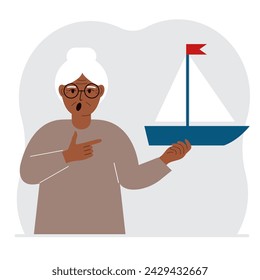 A woman holds a sailing yacht in his hand. Concepts of freedom, hope and big plans. Hobby, sport or business.