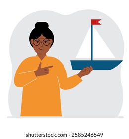 A woman holds a sailing yacht in his hand. Concepts of freedom, hope and big plans. Hobby, sport or business.