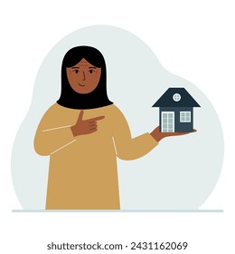 A woman holds a small house in his palm. Concepts of inheritance, real estate transfer, mortgage, credit, loan or house purchase.