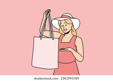 Woman holds textile bag recommending to refuse plastic disposable packages for shopping. Fashionable girl in hats demonstrates rag bag for comfortable visit to supermarket and care for nature.