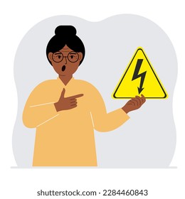 Una mujer sostiene un signo de advertencia triangular amarillo con un rayo negro en la mano. El concepto de peligro de descarga eléctrica o alta tensión. Ilustración plana vectorial.