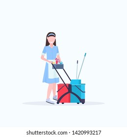 woman housemaid holding trolley cart with supplies female cleaner janitor in uniform cleaning service concept flat full length