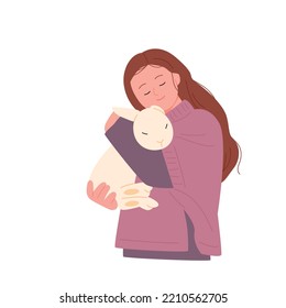A woman is hugging a white rabbit.