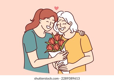 Woman hugs elderly mother and gives bouquet of flowers congratulating with birthday or mother day and thanks for good upbringing. Grown up daughter takes care of mother of retirement age  svg