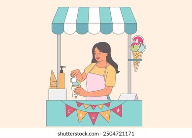 Woman ice cream seller puts fruit balls on waffle cone to prepare delicious dessert for customer. Girl works in small shop with inscription ice cream on flags and striped roof protection from sun.