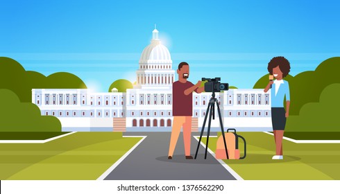 woman journalist with reporter man presenting live news african operator using video camera on tripod recording correspondent movie making concept horizontal white house washington ds background