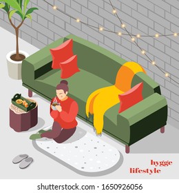 Woman in knitted sweater sitting on floor rug sipping hot chocolate hygge lifestyle isometric background vector illustration  