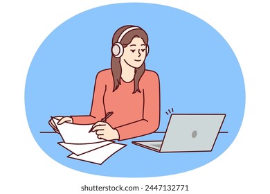 Woman with laptop sits at table and watches training webinar for gaining new skills and makes notes on paper. Attentive girl in headphones using laptop to get online education at university or college