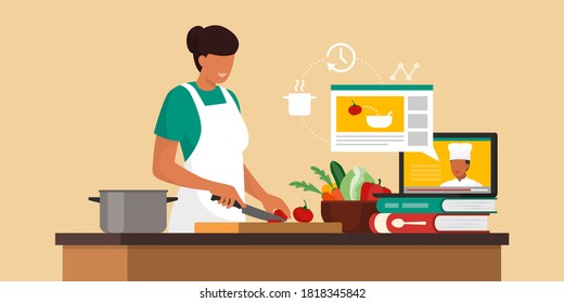 Woman learning recipes online, she is chopping vegetables and watching a video of a chef explaining how to prepare food