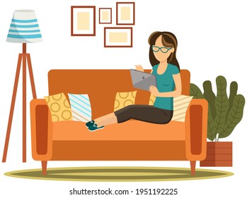 Woman lies on couch with computer. Girl student resting and surfing internet in living room interior