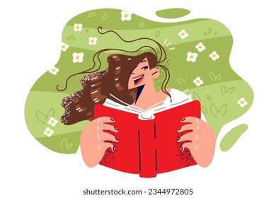 Woman lies on grass and reads book, rejoicing at opportunity to relax in summer park and relax after college classes. Happy girl with book is fond of fiction located on lawn in backyard