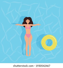 The woman lies in the pool. Summer vacation, swimming, sports.