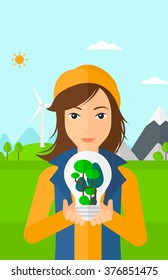 Woman with lightbulb and trees inside.