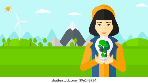 Woman with lightbulb and trees inside.