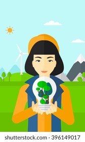 Woman with lightbulb and trees inside.