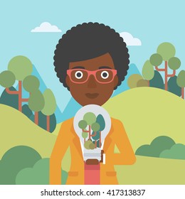 Woman with lightbulb and trees inside.