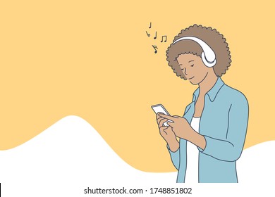 Woman listening music concept. Young happy smiling african american woman holding mobile phone and enjoys musical songs with headphones or play games on smartphone. Leisure time and home recreation.