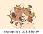 Woman with long flowing hair lies among autumn leaves and smiles rejoicing at onset of september. Woman with bare shoulders for advertising cosmetics or shampoo made on basis of herbs and plants