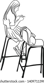 The woman is look into her smartphone and sitting beside her bag on a high chairs.