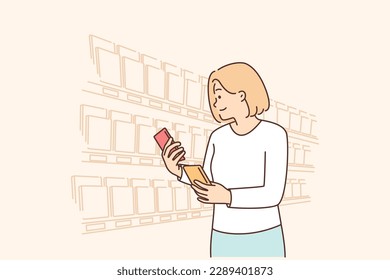 Woman looking for sweet chocolate on grocery store shelves choosing low calorie breakfast dessert. Girl stands in supermarket with chocolate bars reading composition or checking expiration date