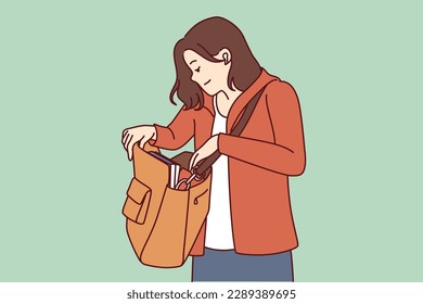 Una mujer mira una gran bolsa colgando del hombro en busca de una cartera o teléfono perdido en un bolso. Una chica turística con bolso vestido con ropa informal está tratando de encontrar objetos personales perdidos o robados. 