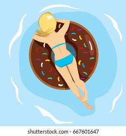 Woman lying back on inflatable doughnut shaped in summer at swimming pool