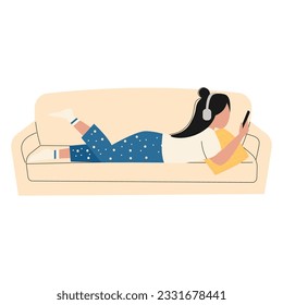 A woman is lying on the couch holding a smartphone in her hand. Girls on the couch use the phone to chat and surf the Internet