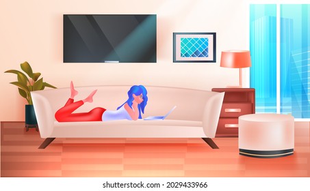 woman lying on sofa and using laptop social media network online communication relaxation concept