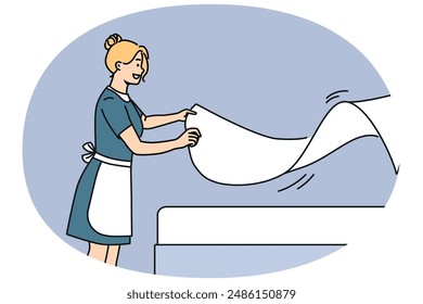 Woman maid makes bed with sheets, preparing hotel room for arrival of new guests. Maid with smile doing job enjoying career in hospitality industry and becoming professional in horeca industry